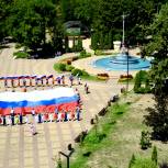 Активисты «Единой России» и «Молодой Гвардии» развернули 15-метровый российский триколор в Майкопе