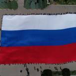 «Молодая Гвардия Единой России» и «Волонтёрская Рота» развернули самый большой флаг России в Мариуполе