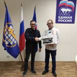 Озерские партийцы вручили организаторам «Тифло-кафе» фотоаппарат и проектор