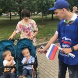 В праздничный день партийцы Западного округа раздали жителя флаги России 
