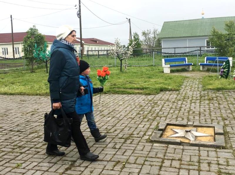 Село Несь: бабушка и внук идут к Обелиску Победы с цветами